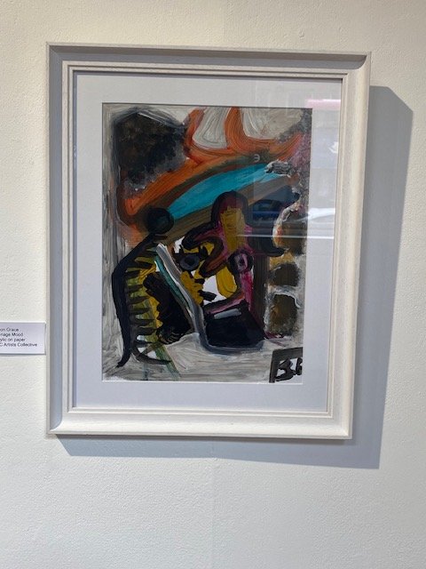 Framed abstract painting with bold brushstrokes in oranges, blues, yellows, and black on a textured background.