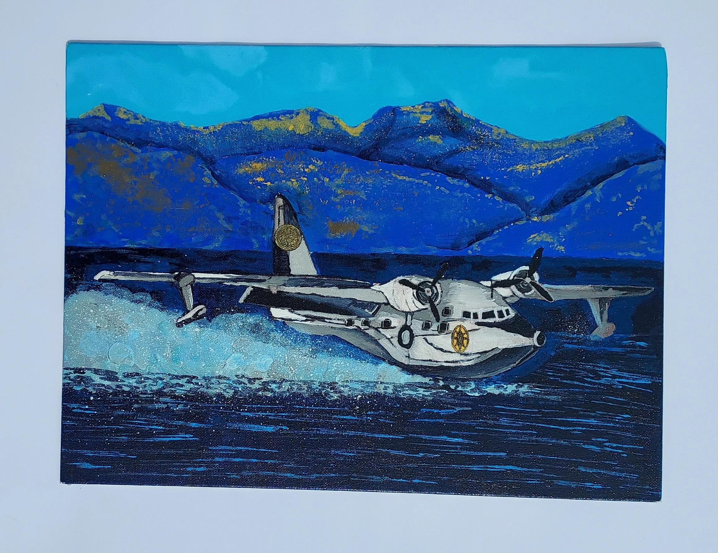 A painting of a white and gray seaplane with two propellers on the wings, taking off from choppy, dark blue water. In the background, a vibrant blue sky meets a range of rugged, blue mountains streaked with gold.