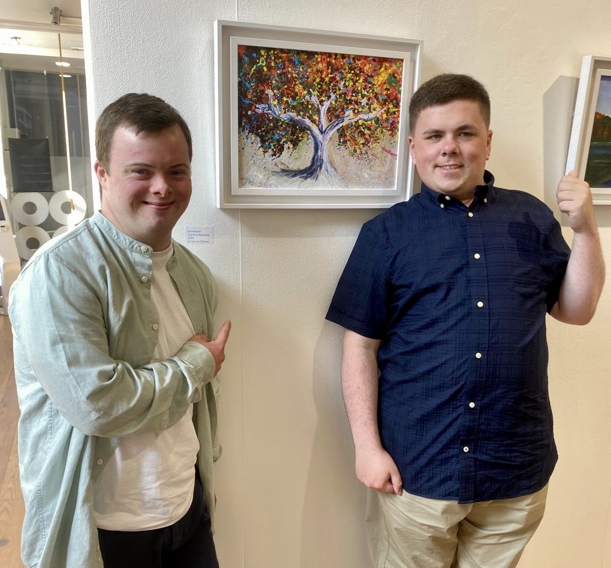 Artists Joe Hallam and Michael Hade standing in front of Joes artwork "The Four Seasons" hanging in the Atypical Gallery.