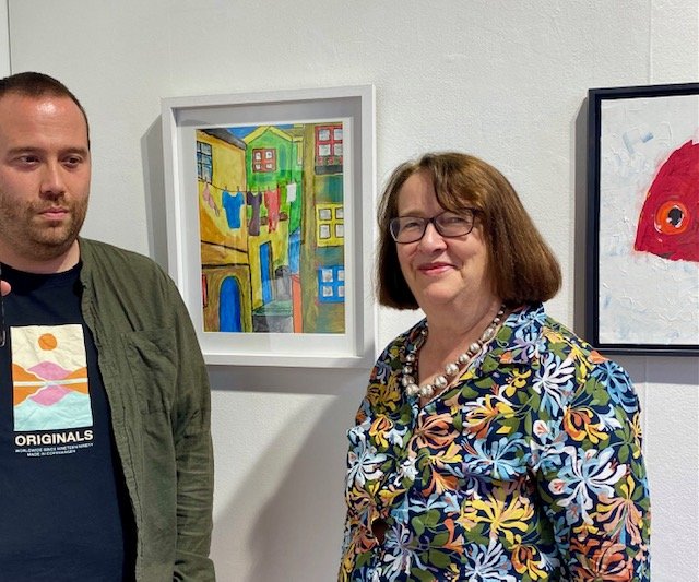 Artist David Singleton and Kate Singleton standing in front of his artwork "Washing Line" at Atypical Gallery