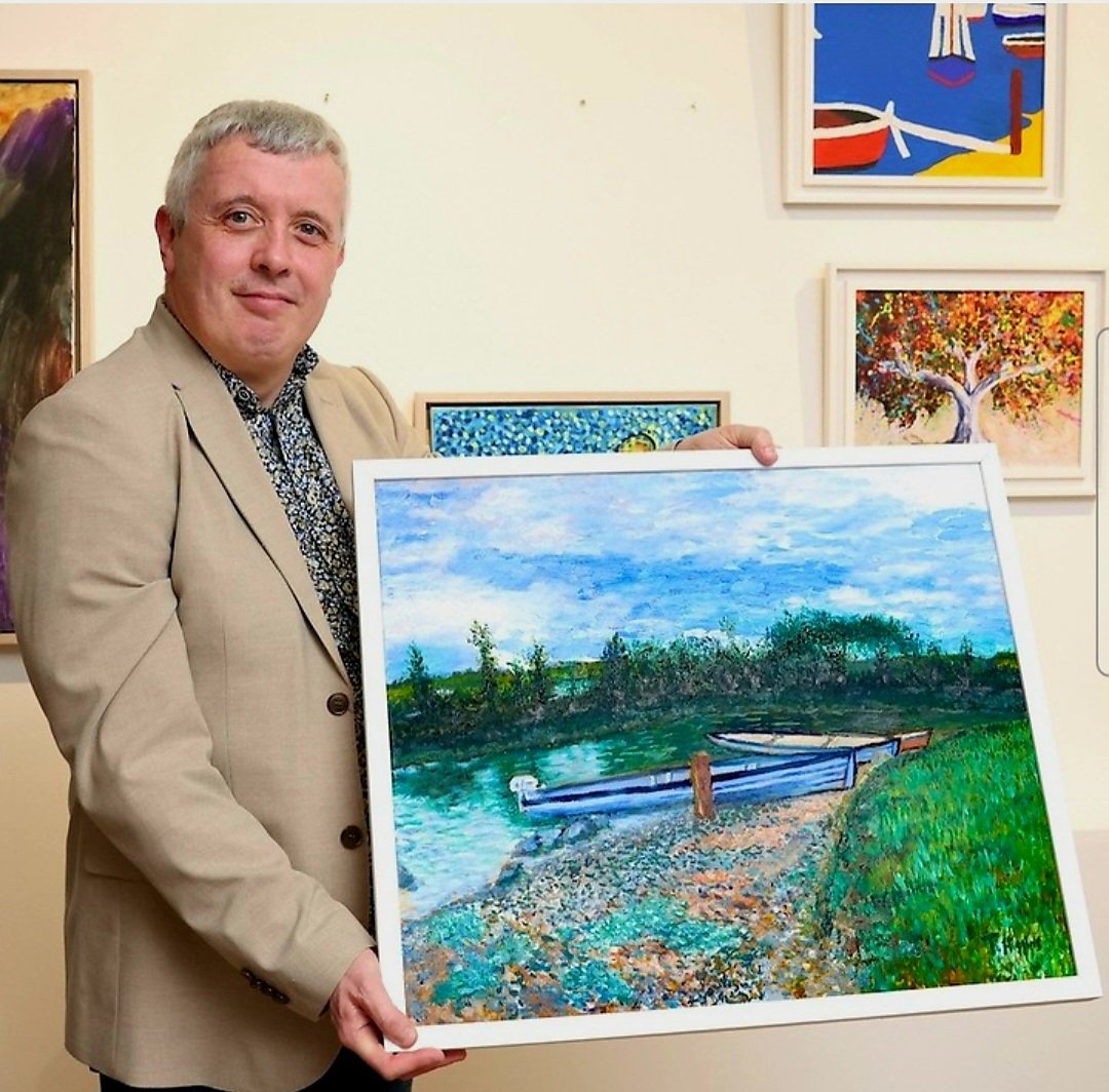 Artist Thomas Higgins holding a piece of his artwork