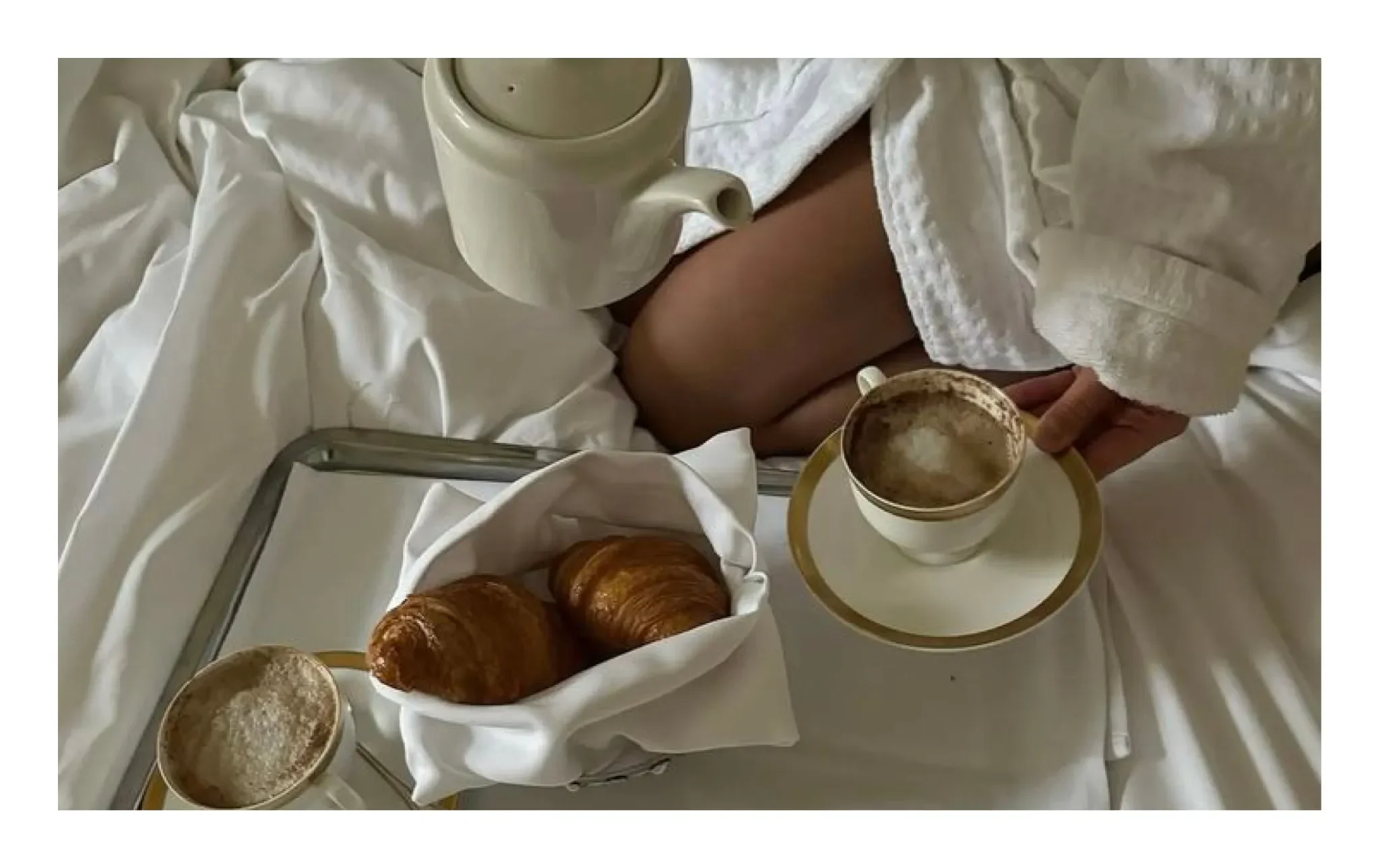 Luxury breakfast in bed with fresh croissants and coffee in a high-end hotel suite, representing a perfect GFE morning date in London or Milan.