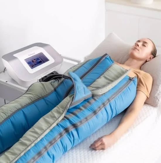 A woman lying on a bed with a compression device wrapped around her, connected to a machine.