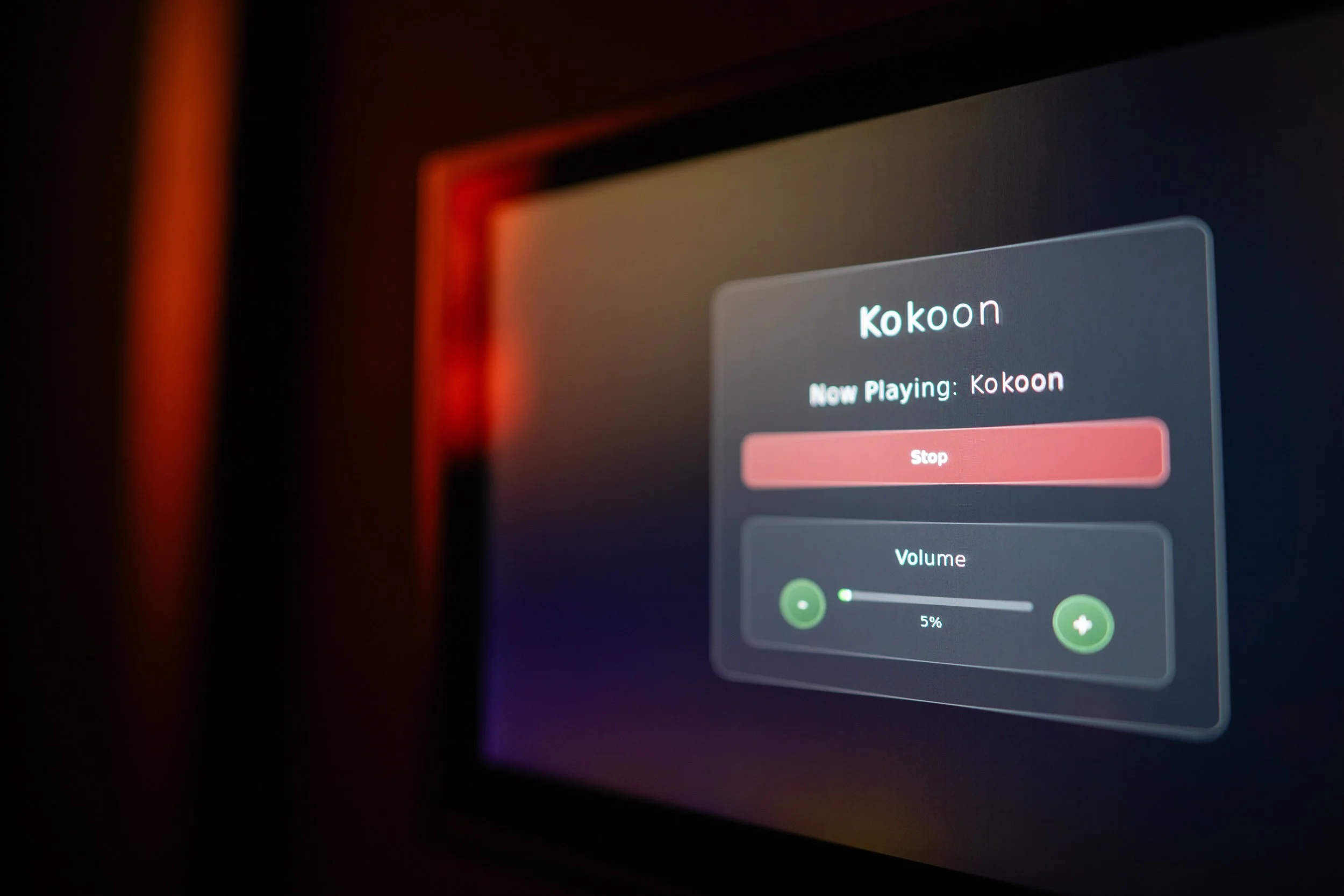 Close-up of a computer or device screen displaying a music player app. The app shows the automation program "Kokoon" currently playing, with options to stop and adjust volume.
