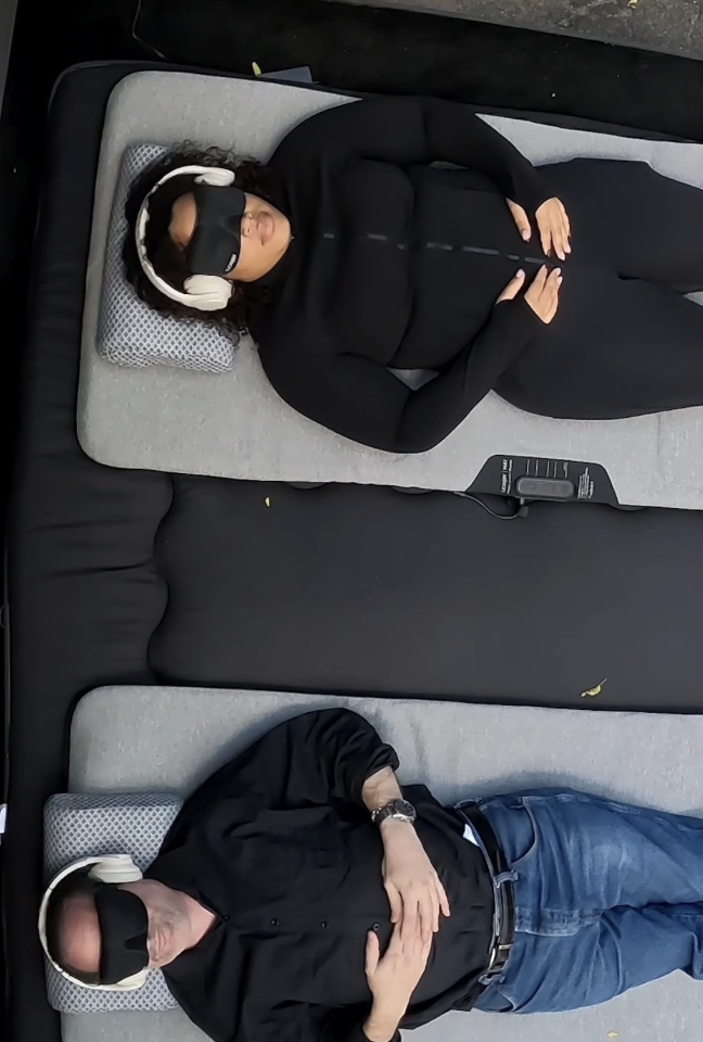 Two people lying on couches with Kokoon-mini headsets and headphones, resting with hands on their stomachs.