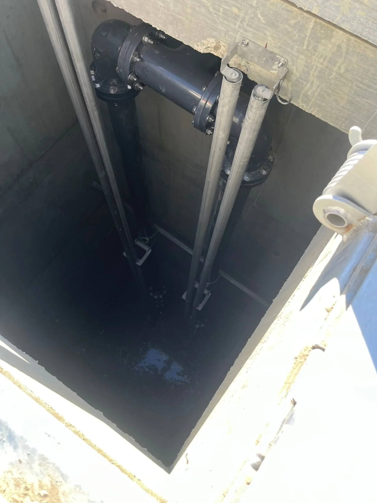 Installed pump basin with discharge piping and guide rails