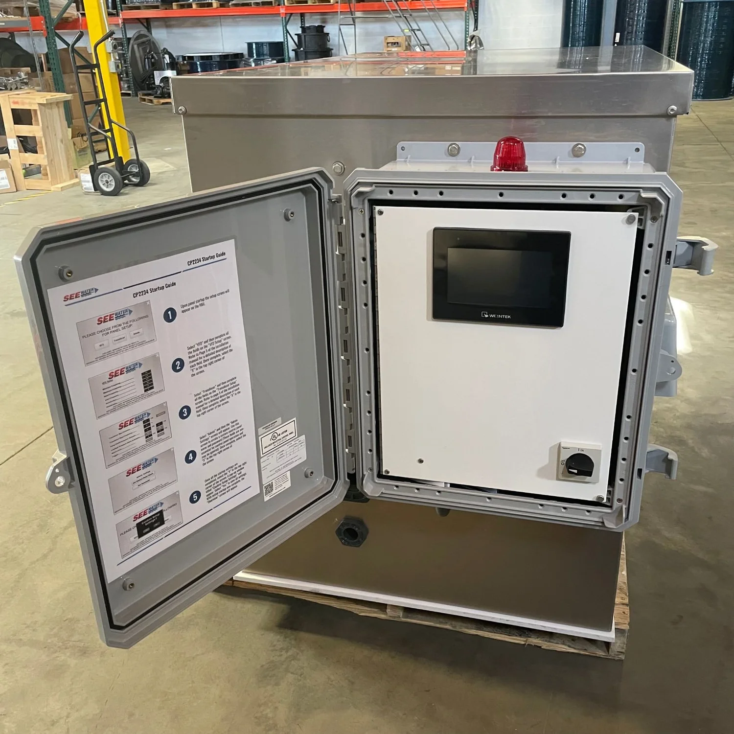 Open control enclosure with an operator display, wiring, and equipment documentation.