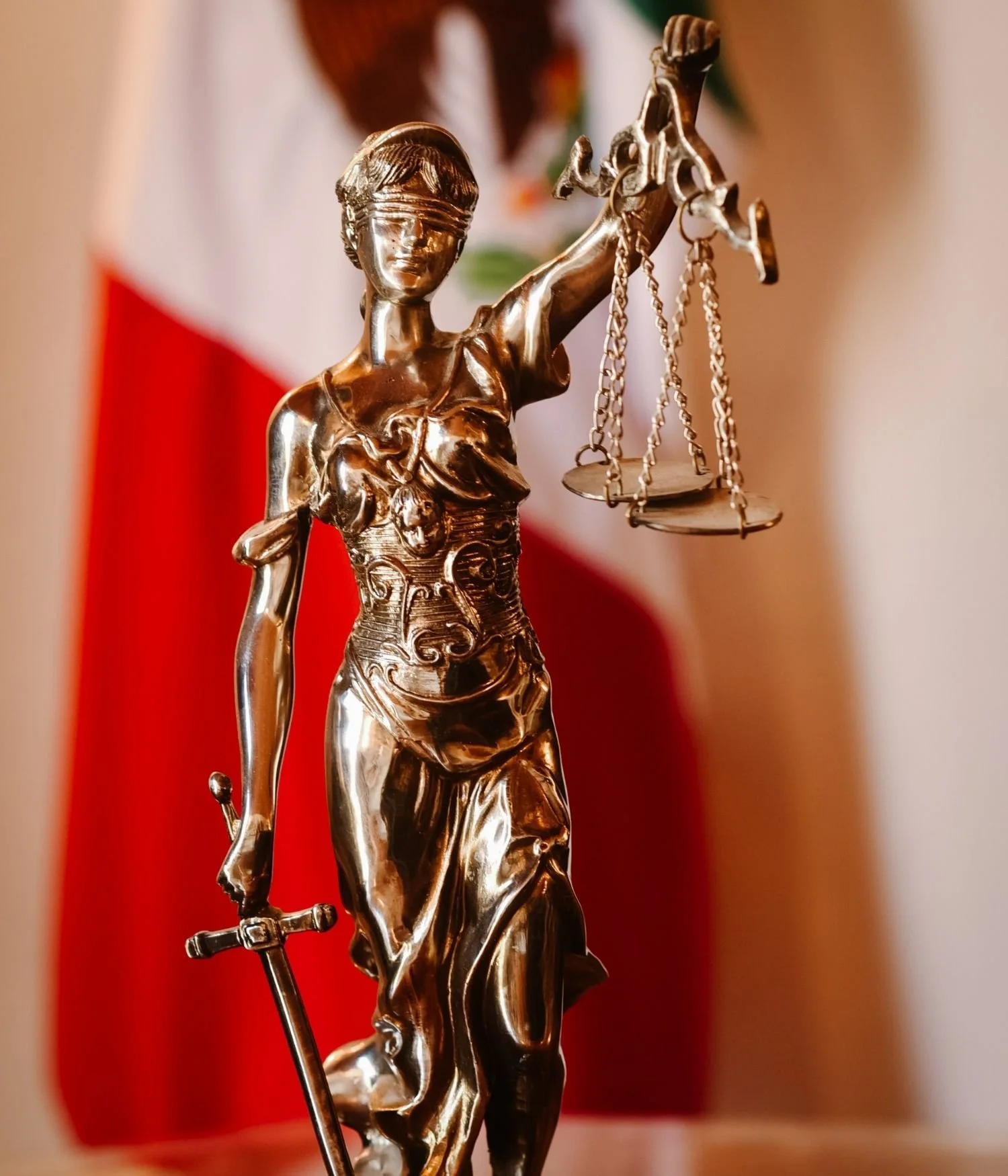 Lady Justice statue with Mexican flag representing legal and compliance services in Mexico.