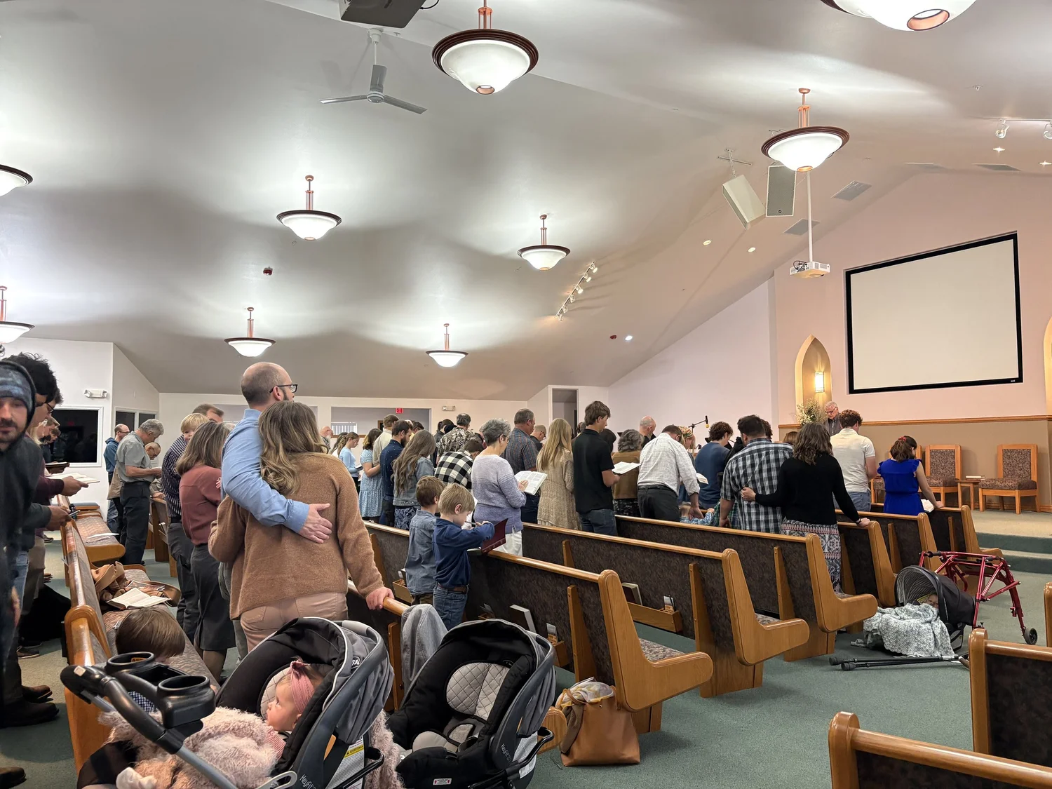 The Providence Bible Church congregation gathering for worship, with families standing together in the pews.