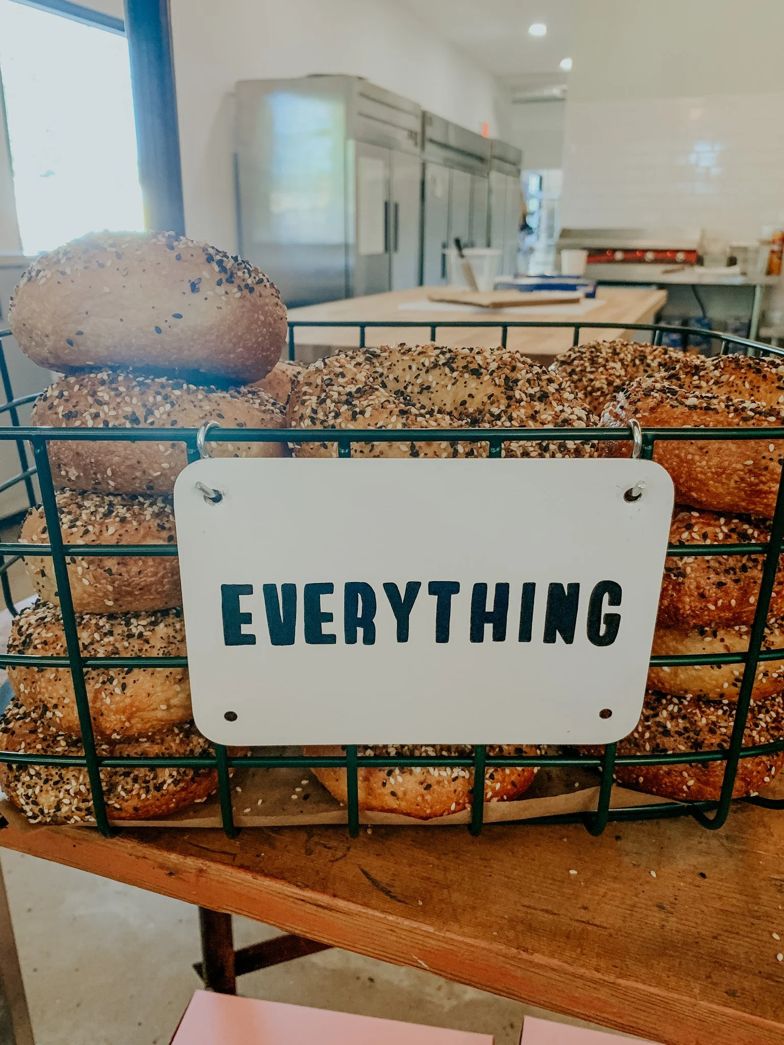 Basket of everything bagels on a table in a bakery.