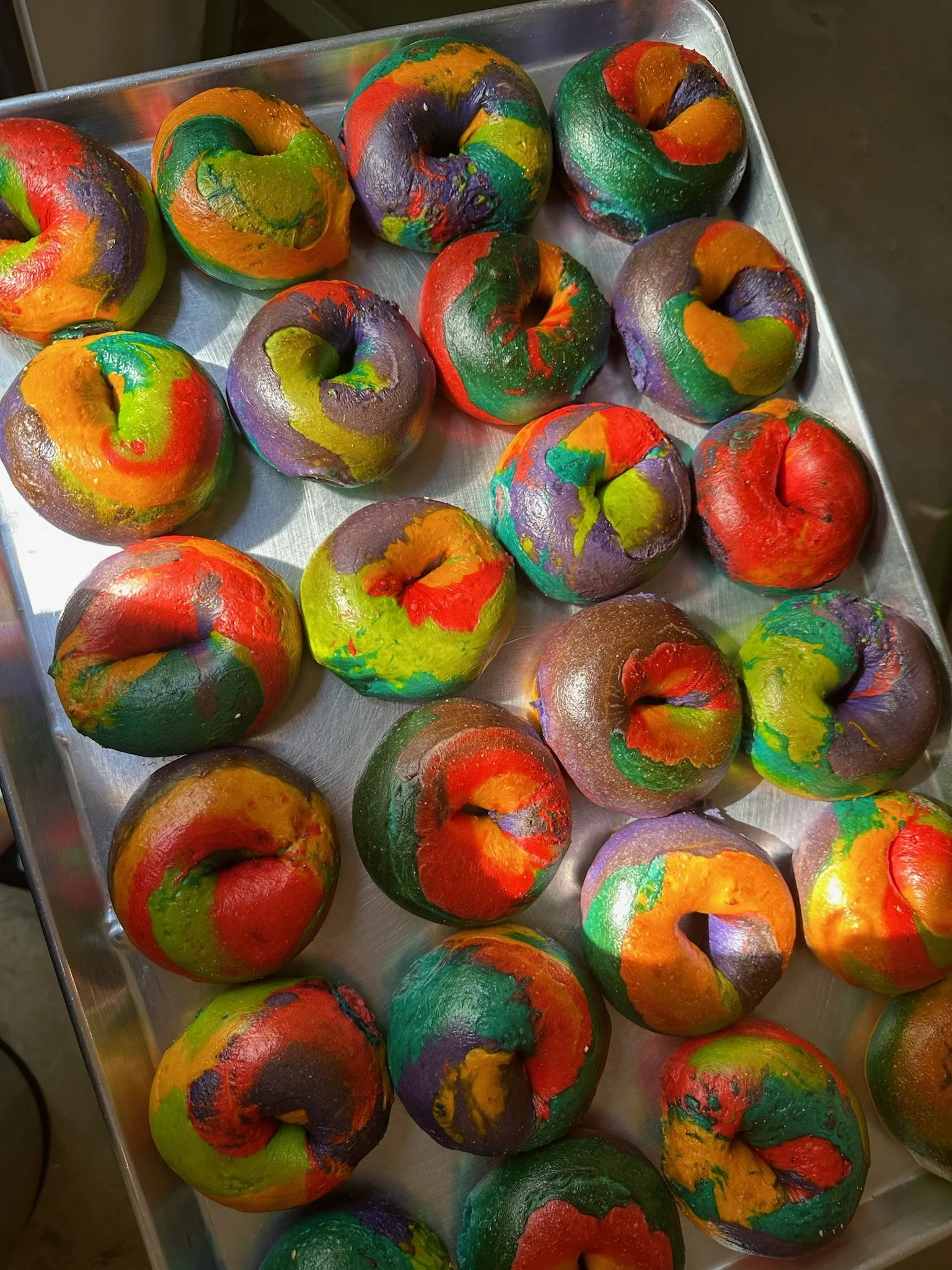 Tray of colorful rainbow bagels