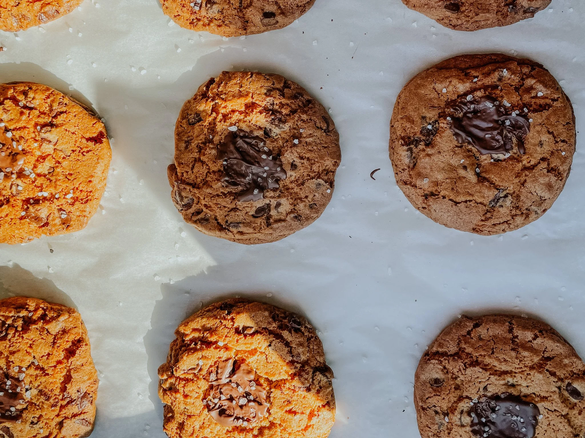 Chocolate chip cookies with sea salt on parchment paper