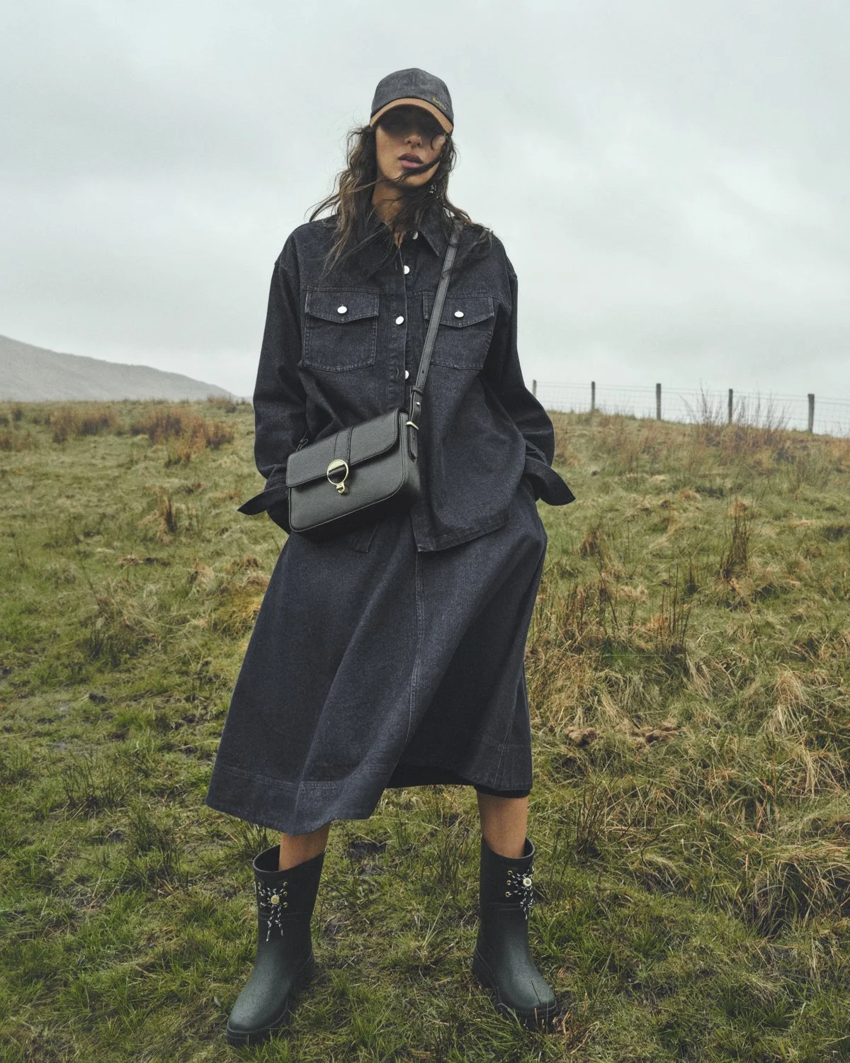 A female model poses in a denim outfit in Scotland for Barbour SS26. Photographer Dan Jackson.