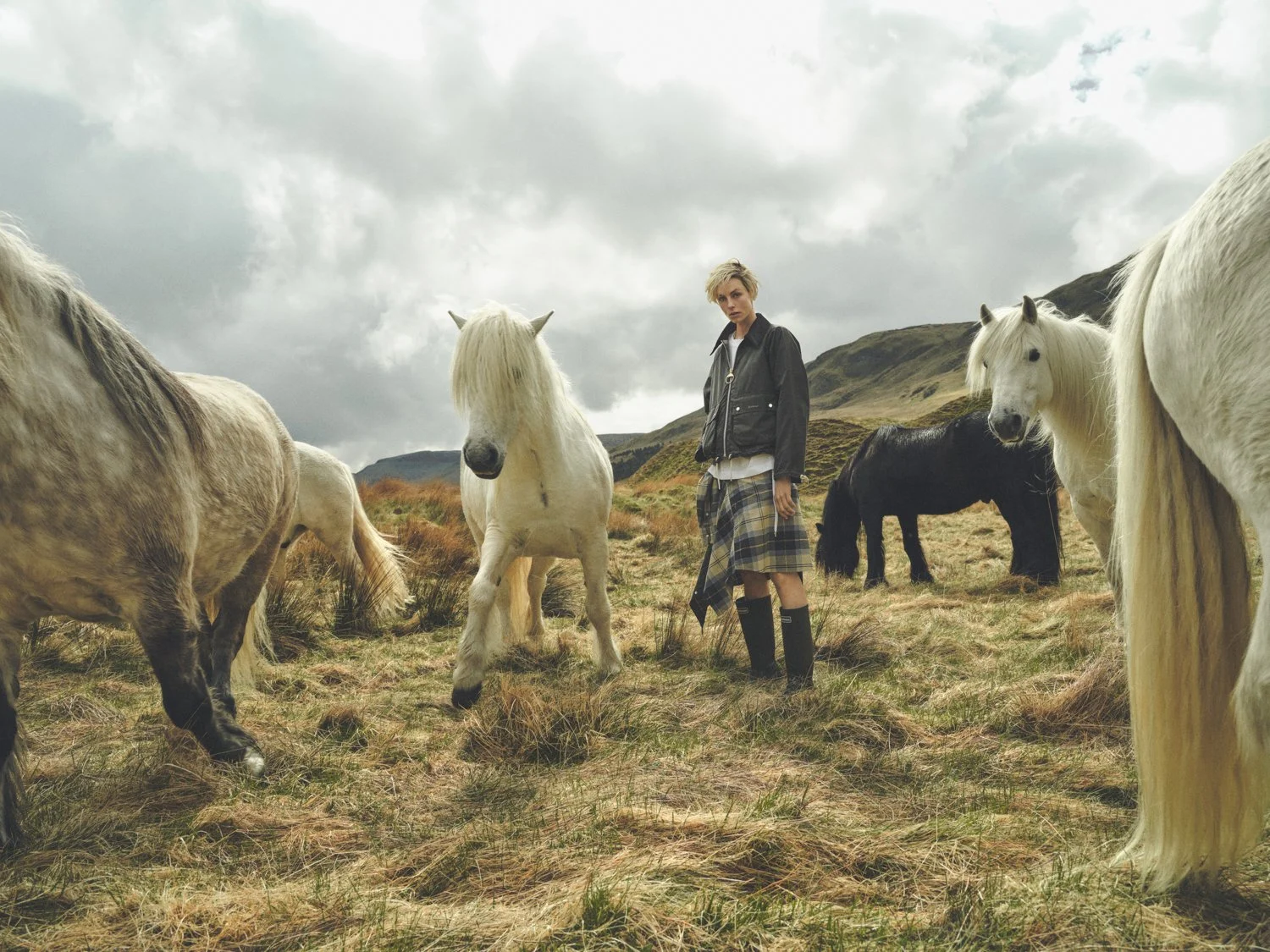 Model, Edie Campbell, captured by Dan Jackson with working horses while on a photoshoot for Barbour in the Scottish Highlands