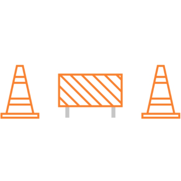 Road construction scene with orange traffic cones and a barricade.