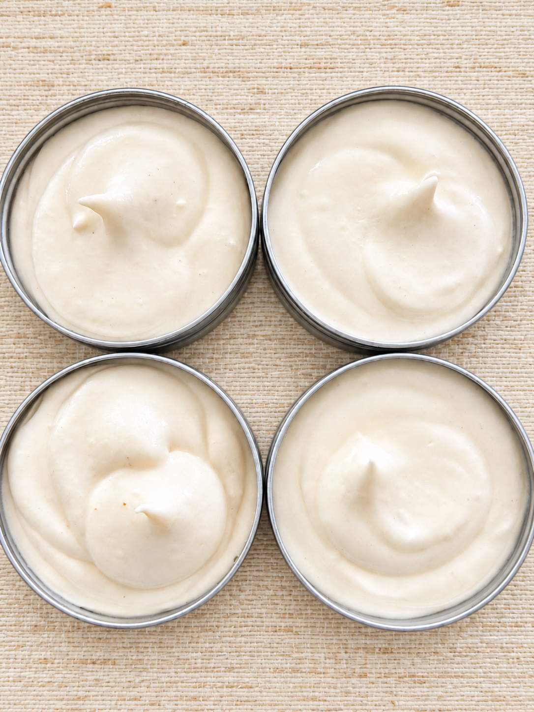 Four Ivory Cream Tins on Grasscloth.png