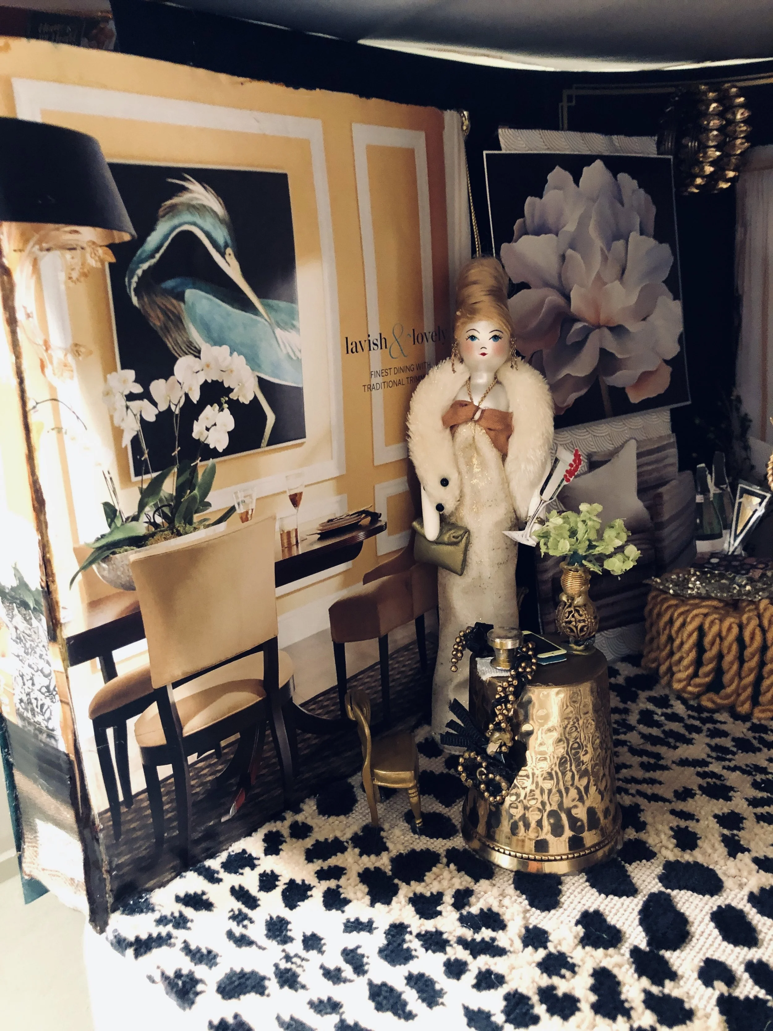 Dining Room Cocktail table brass candle holder turned upside down, gold braided purse on table, Chanel purse piece of vinyl and pieces of gold necklace chain.