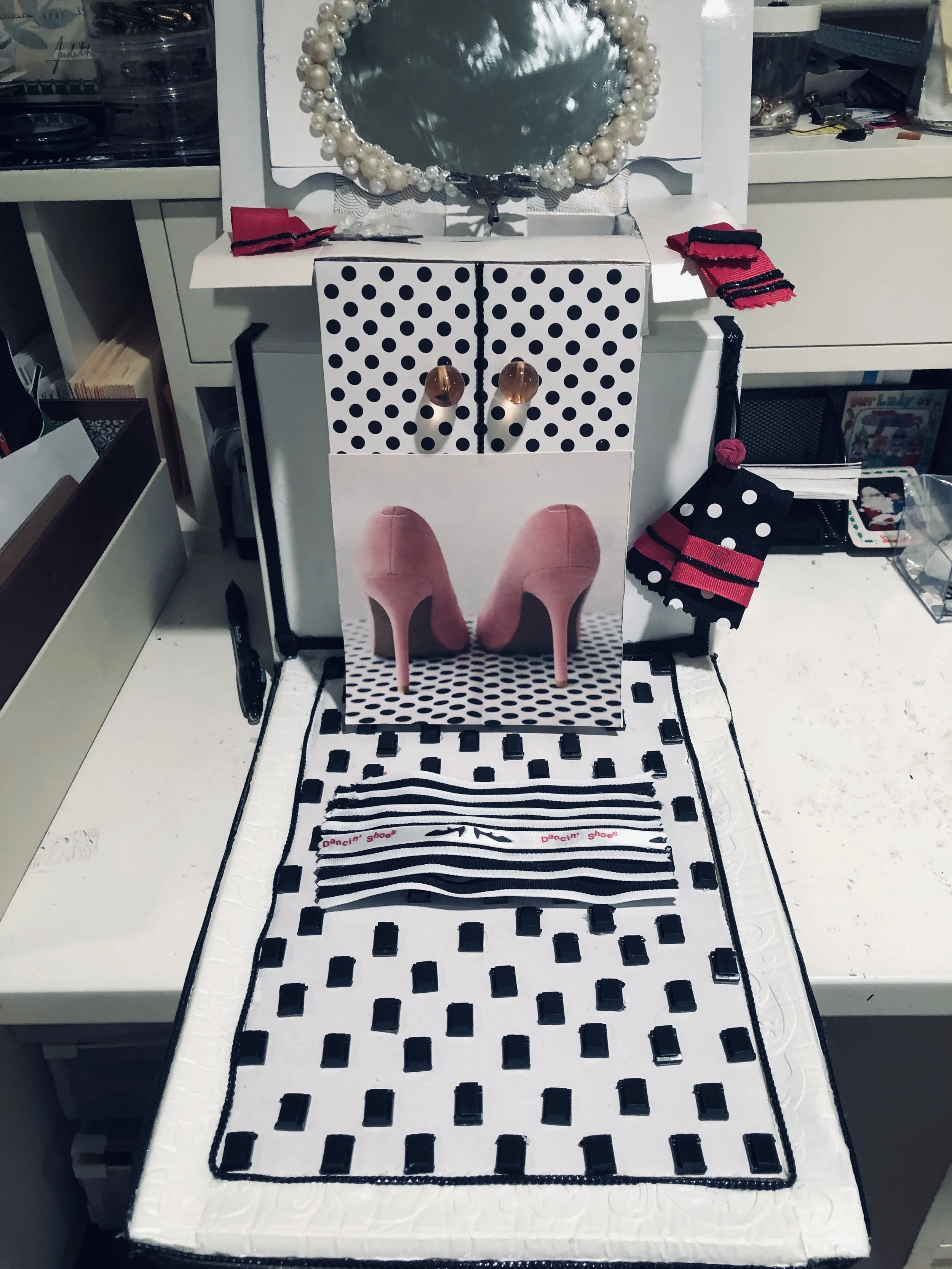 sink vanity, buttons for door knobs , shows recycled greeting card cut outs .