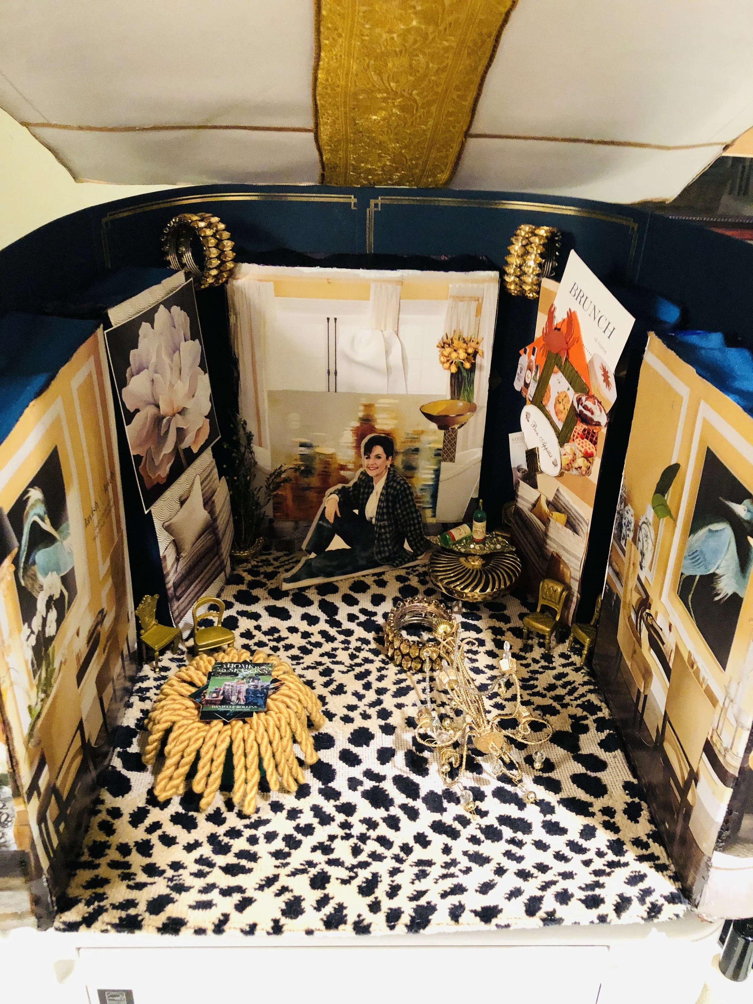 Miniature room with animal print carpet, artwork, a woman sitting on the floor, and various furniture and decorative items.