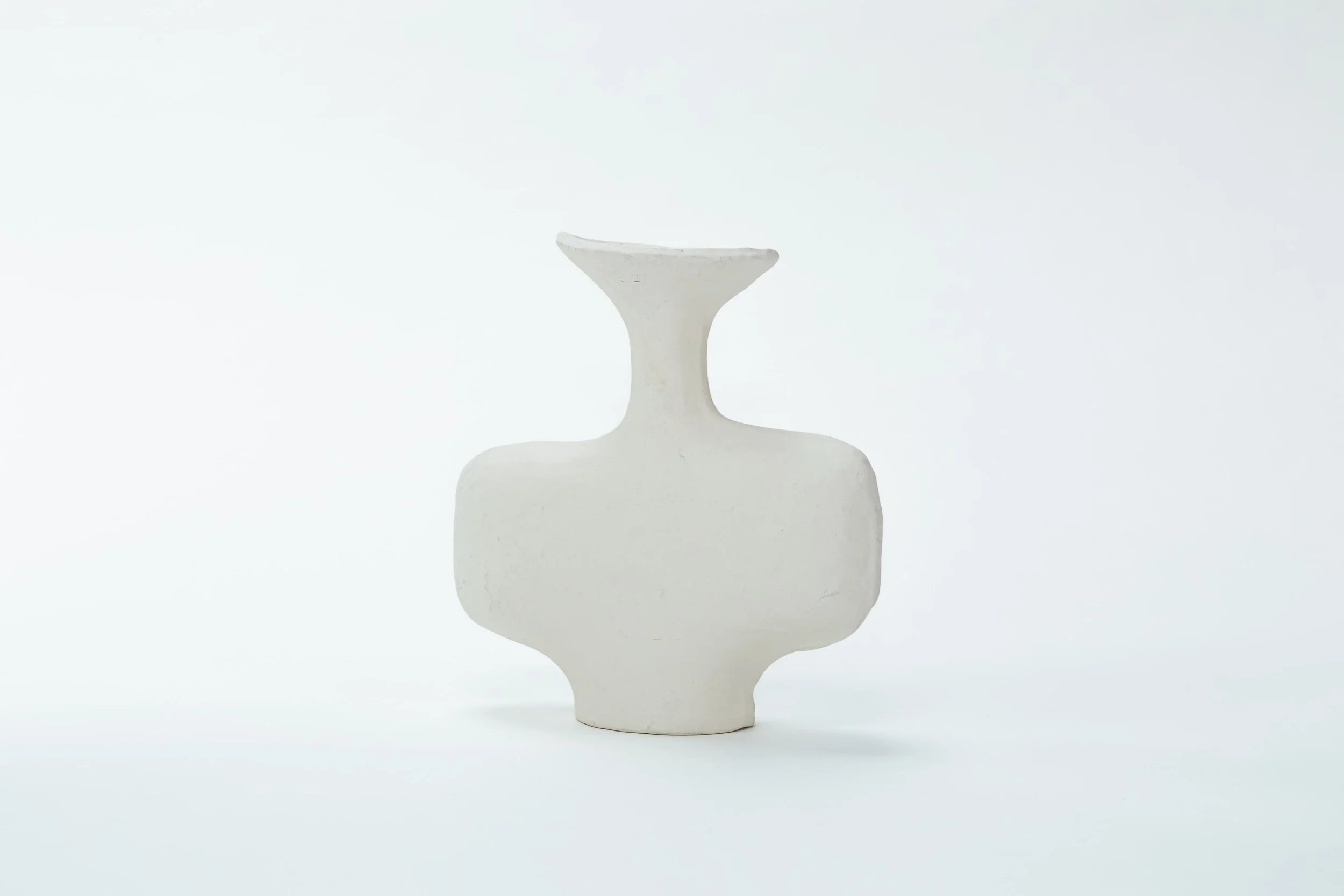 Wit keramische vaas met abstracte vormen, minimalistisch design op een vlak witte achtergrond.