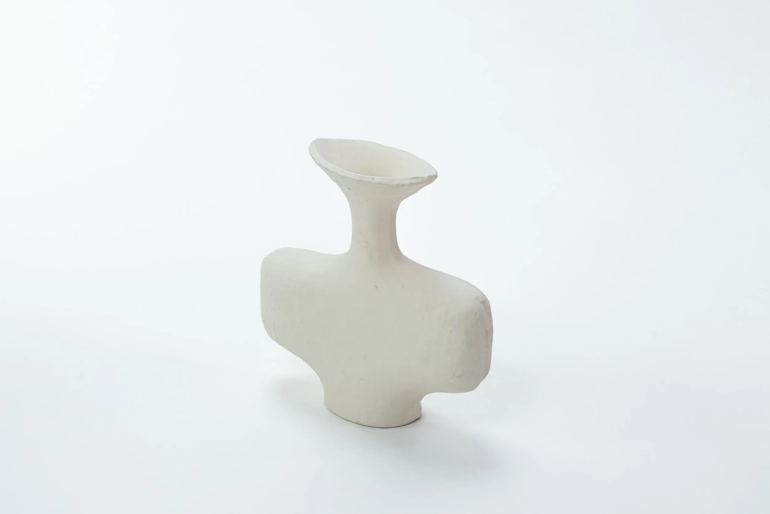 Witte abstracte keramische sculptuur op witte achtergrond.