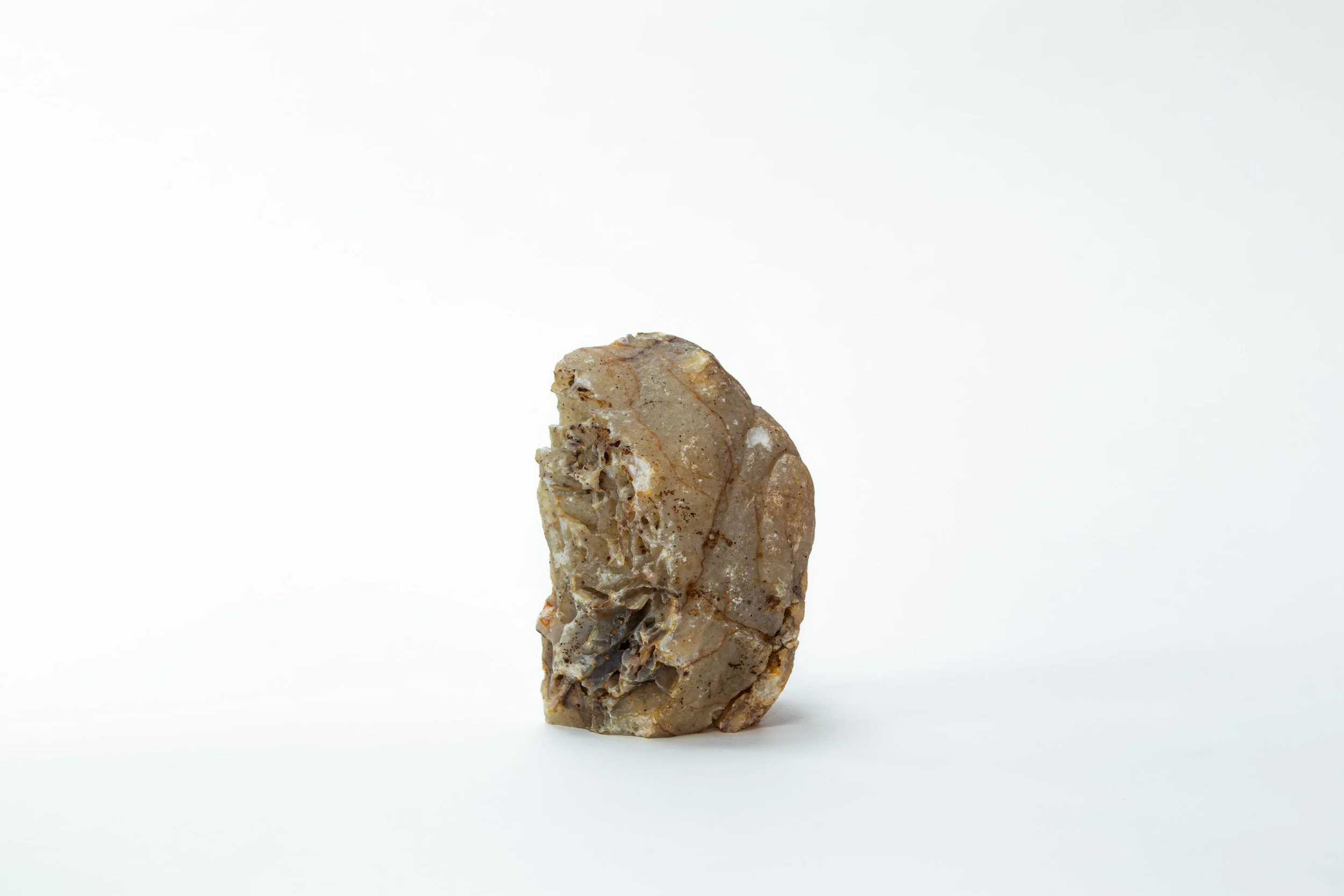 Een ruwe, onbewerkt stuk kalksteen op een witte achtergrond