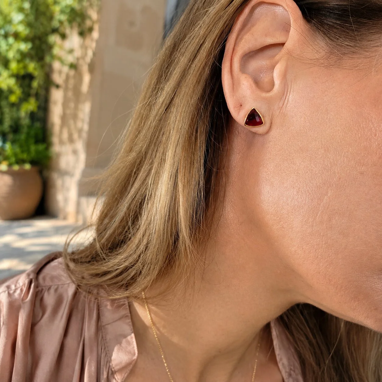 Nahaufnahme eines Models mit Granat Geburtsstein Ohrringen für Januar