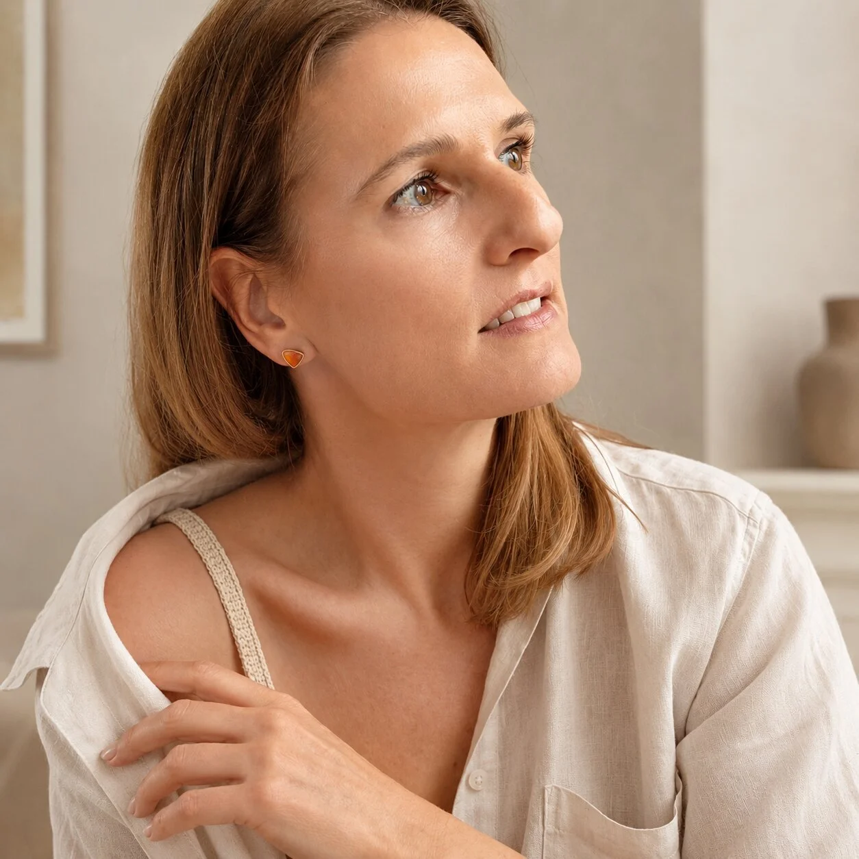 Elegantes Model trägt orangefarbene Sardonyx Ohrringe als besonderen Geburtssteinschmuck für August