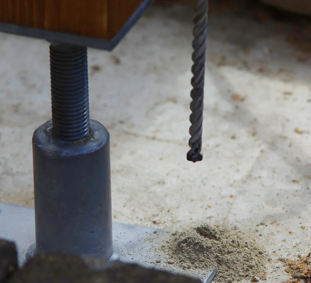 Creusage du sol et fixation des pieds pour stabiliser la pergola