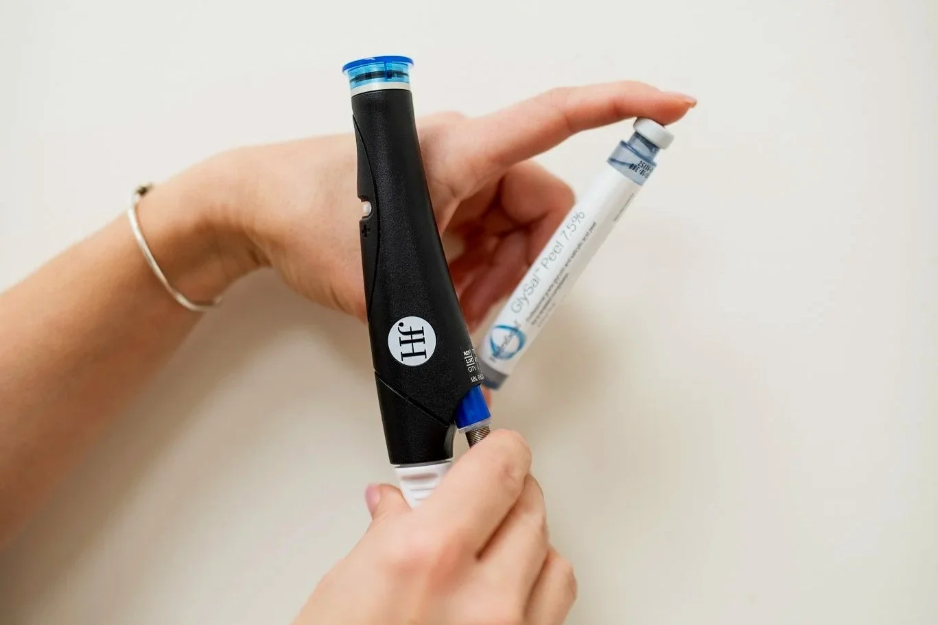 Person holding a glucose meter and a test strip.