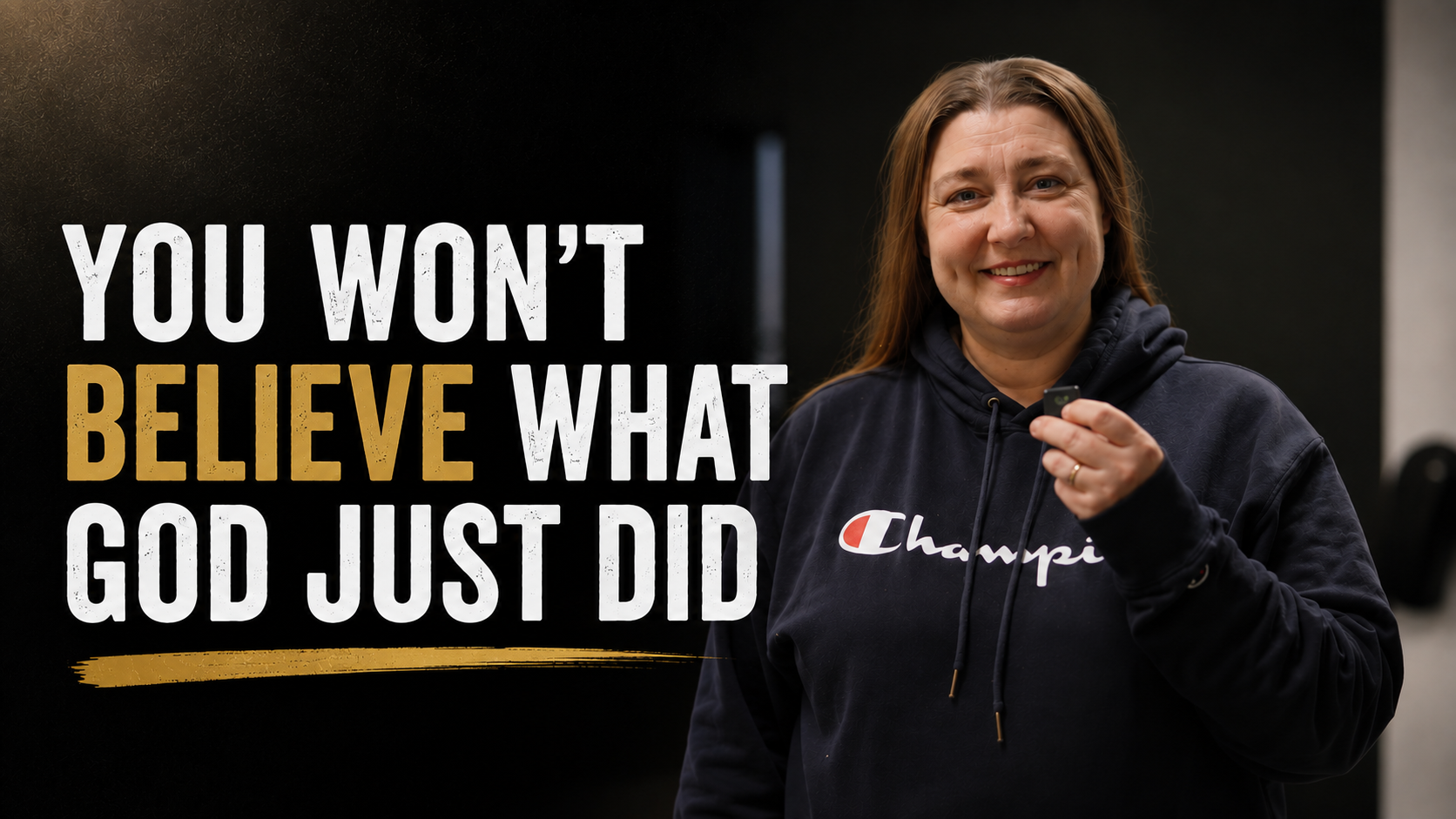 Woman in a navy hoodie holding a small object, standing next to a sign that reads 'You won't believe what God just did'.