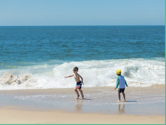 Two children playing in the surf at a Nosara beach rental
