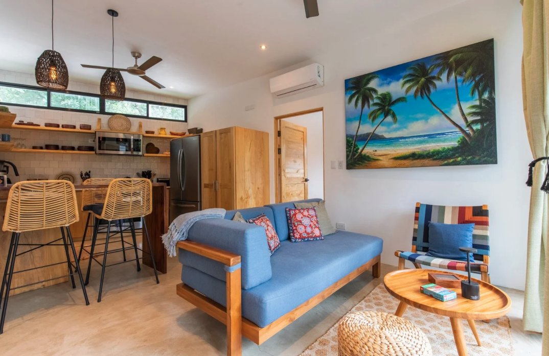 Couch and kitchen in long term Nosara rental home
