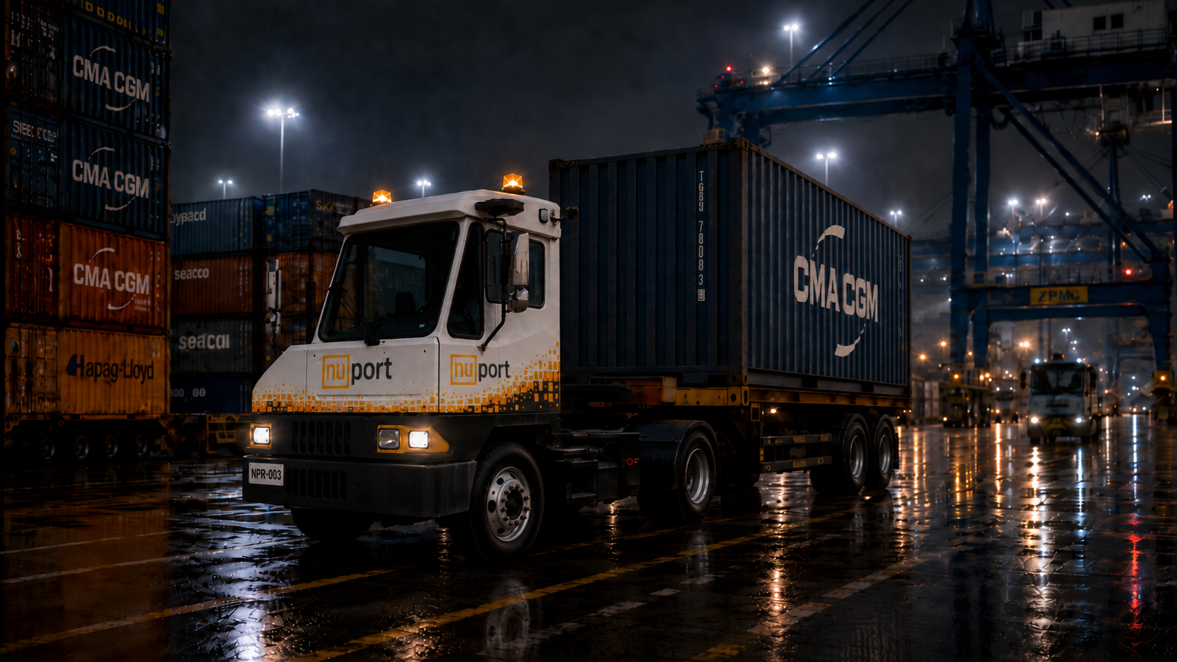 NuPort terminal tractor carrying a shipping container at night