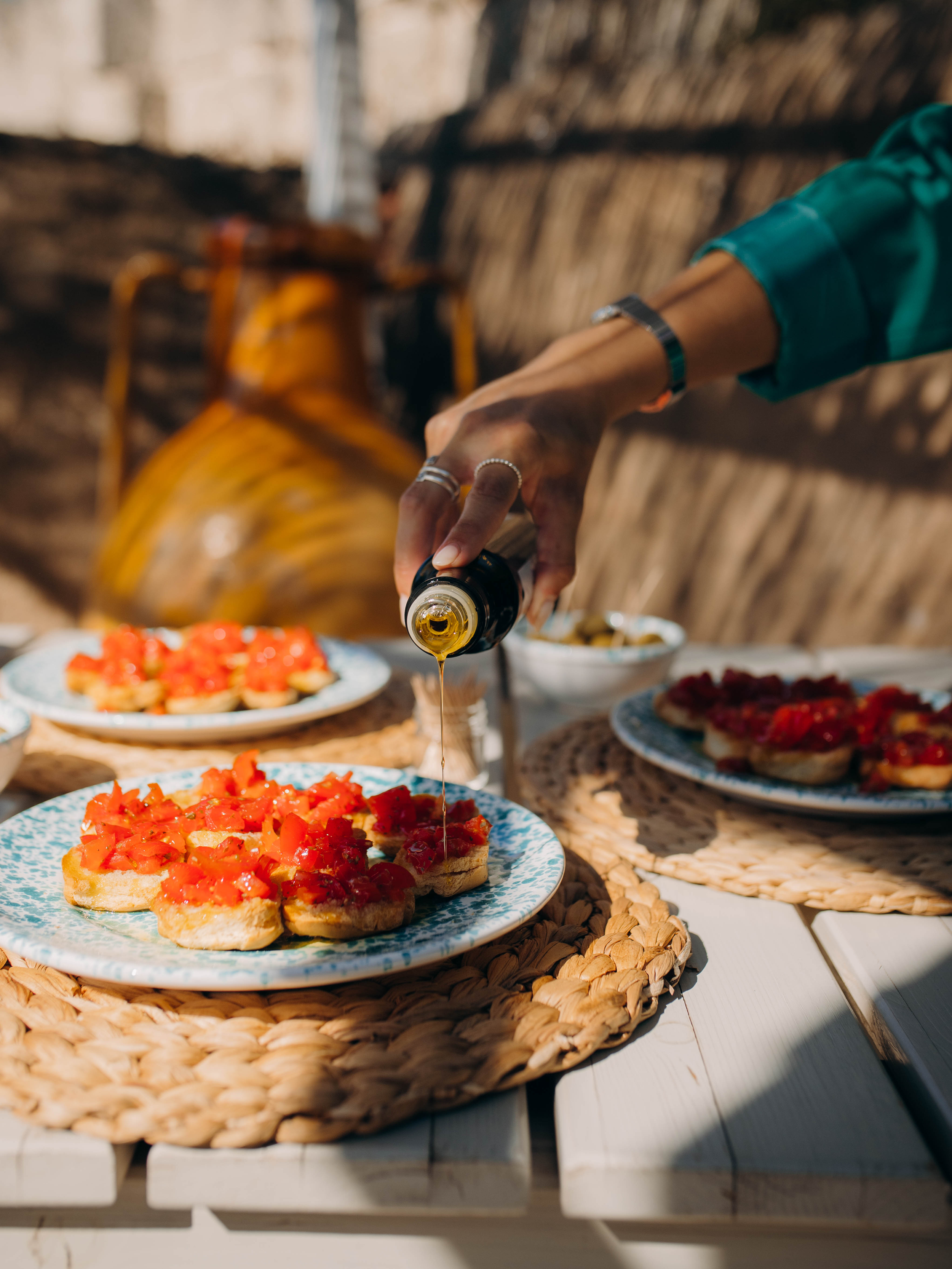 Olive oil being poured on tomatoes