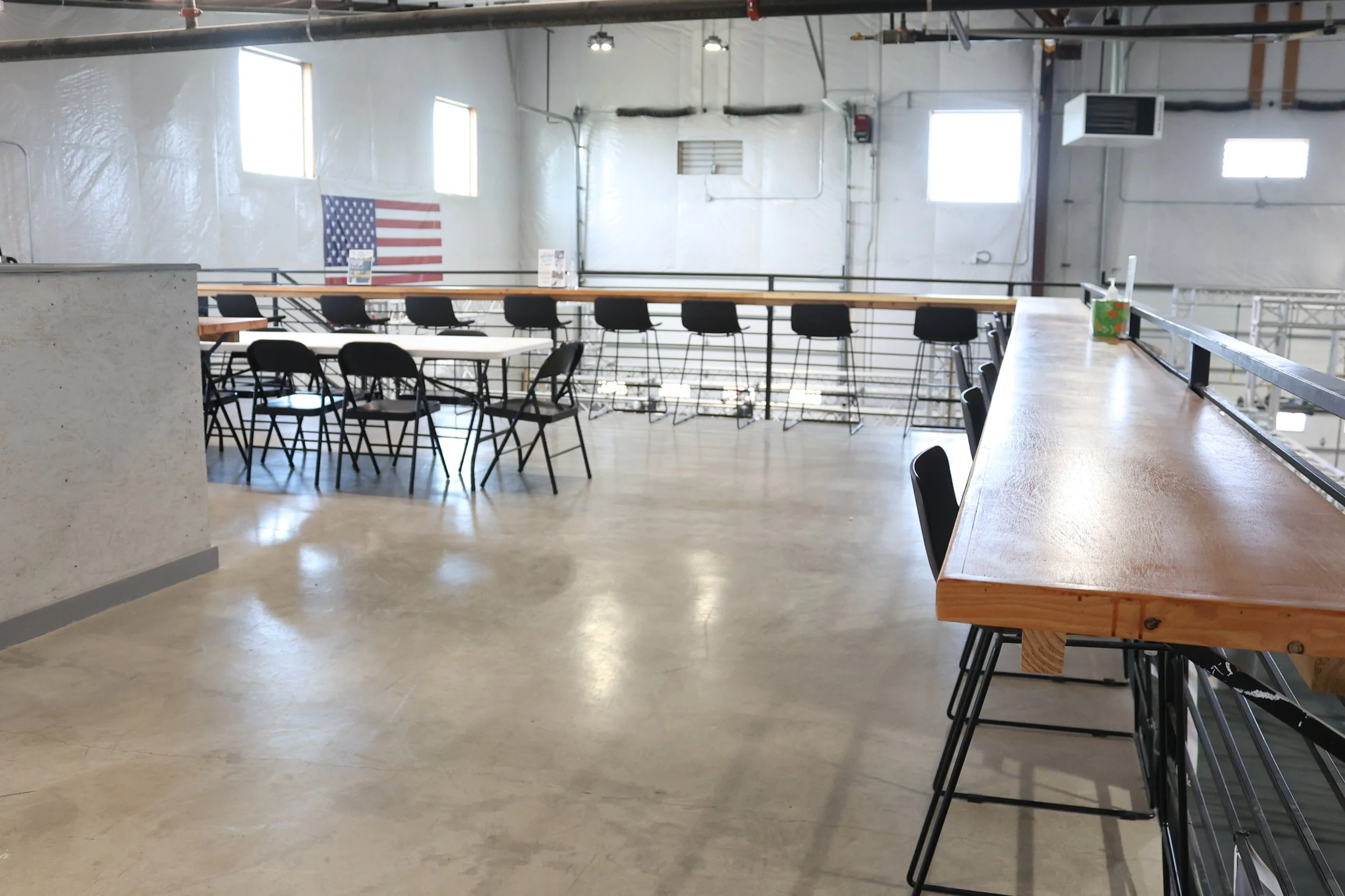 ARK Ninja Longmont gym viewing area with seating, tables, and railing overlooking the ninja training facility.
