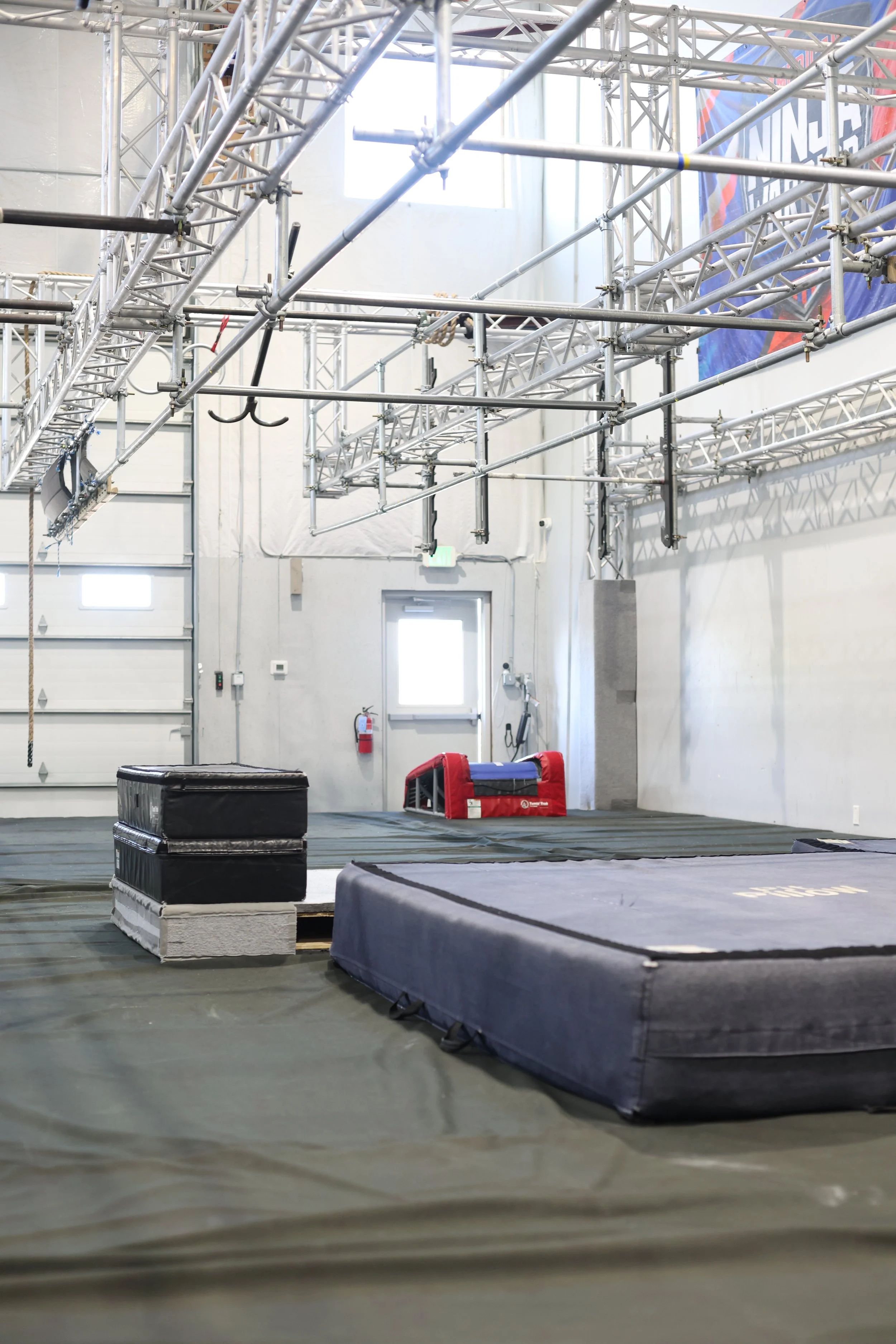 ARK Ninja Longmont indoor ninja gym with suspended obstacle course, climbing obstacles, and padded landing mats.