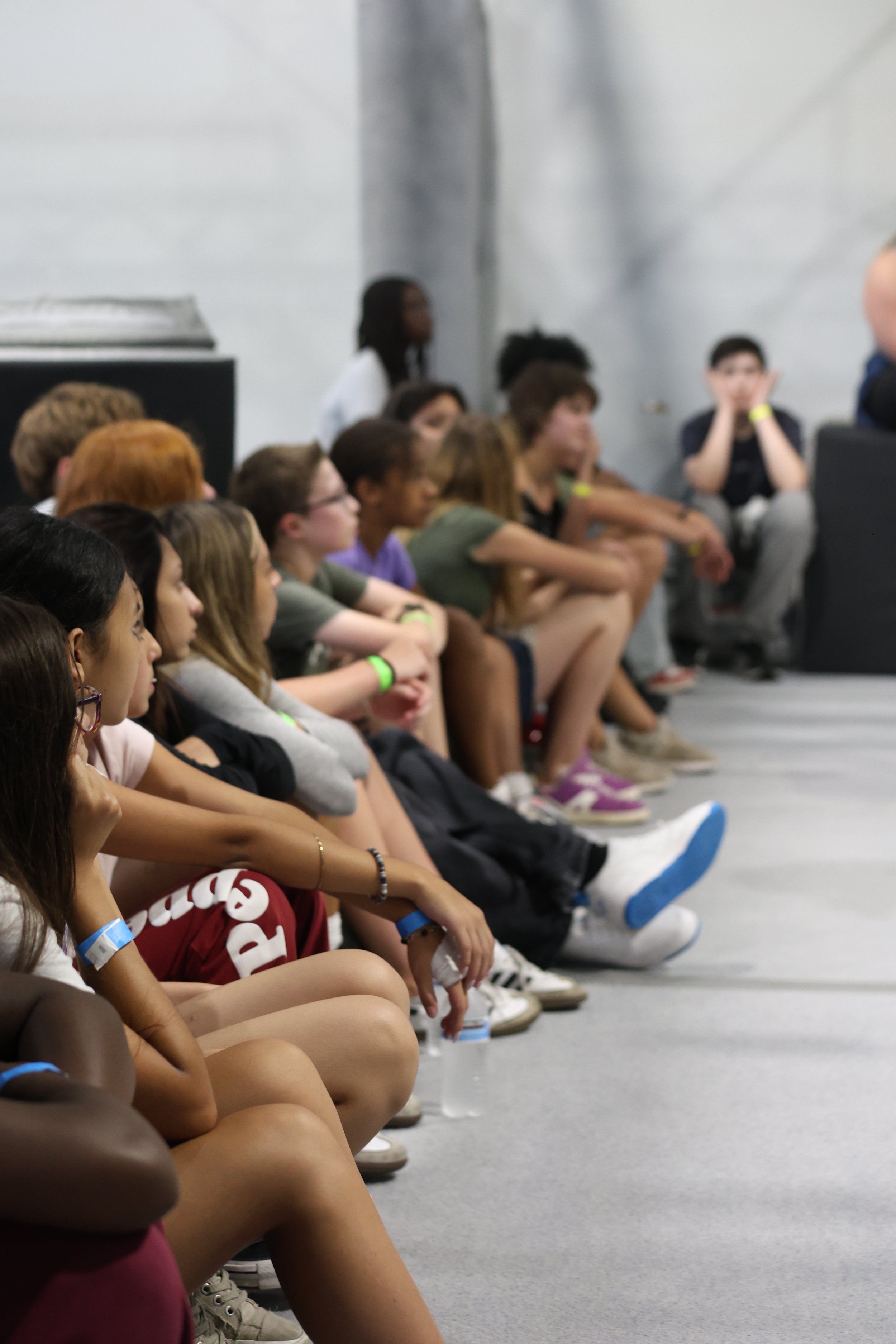 Students sitting together and listening to rules during a school field trip orientation at Ark Ninja Warrior gym in Longmont, Co