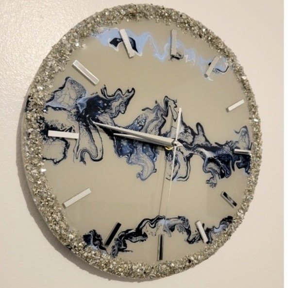 Decorative wall clock with a silver glittery border and abstract black and white marbled design inside, showing the time as approximately 10:49.