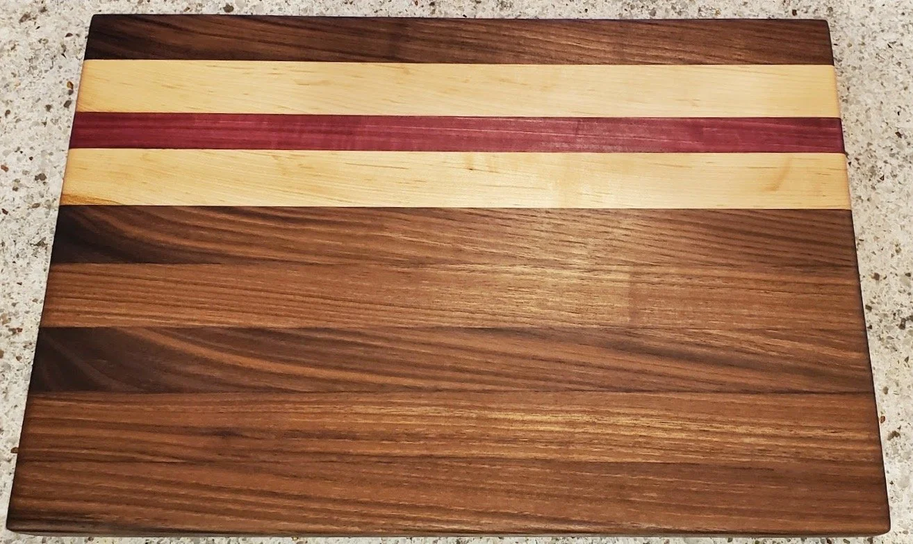 walnut cutting board with maple and purple heart strips