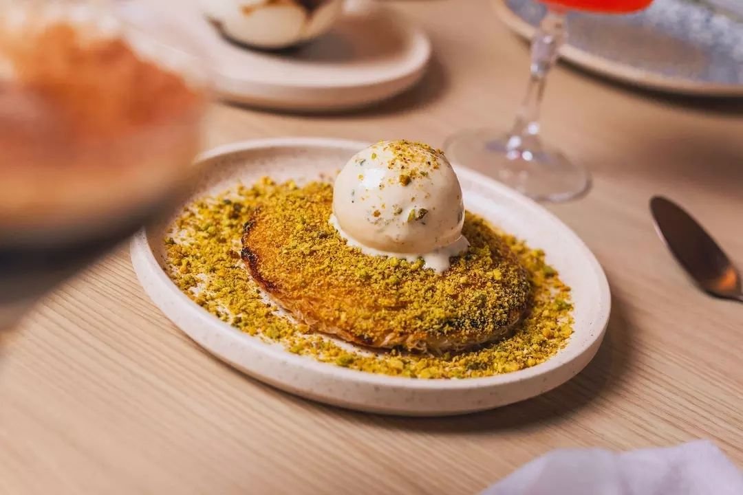 Dive into our Kunefe three-cheese delight, drizzled with orange blossom, sprinkled with Iranian pistachios, and crowned with burnt honey ice cream. 

Rumour has it, that our Kunefe three-cheese dessert is so good, it has its own fan club! 🧀🍨 Prepar