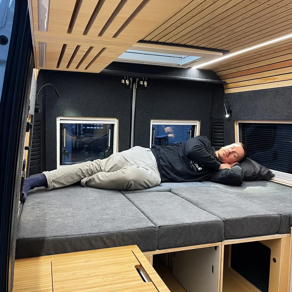 cm-campermodule-bettmodul-b3-140-raumansicht-bett-querschlafen-querschlaefer-mitperson-1000x1000-eingebaut-2.jpeg