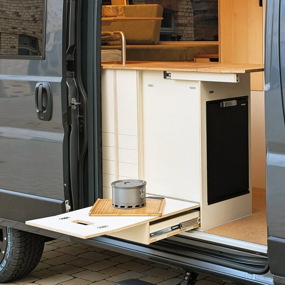 cm-campermodule-kochmodul-k4-rueckansicht-aussenklapptisch-ausgeklappt-schublade-unten-offen-arbeitsflaechenerweiterung-ausgekalppt-sand-1000x1000-eingebaut.jpg