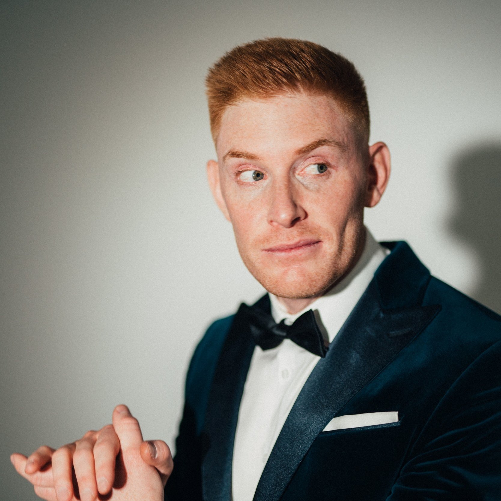  Matt Gore wearing a suit, posing confidently, with ginger hair and blue eyes. 