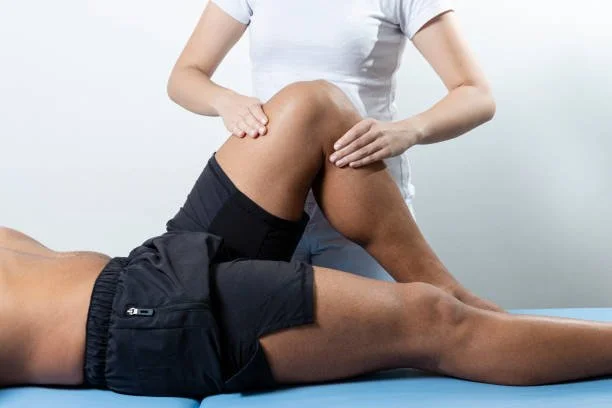 Physiotherapeut behandelt das Knie eines Mannes bei einer Physiotherapie-Sitzung.