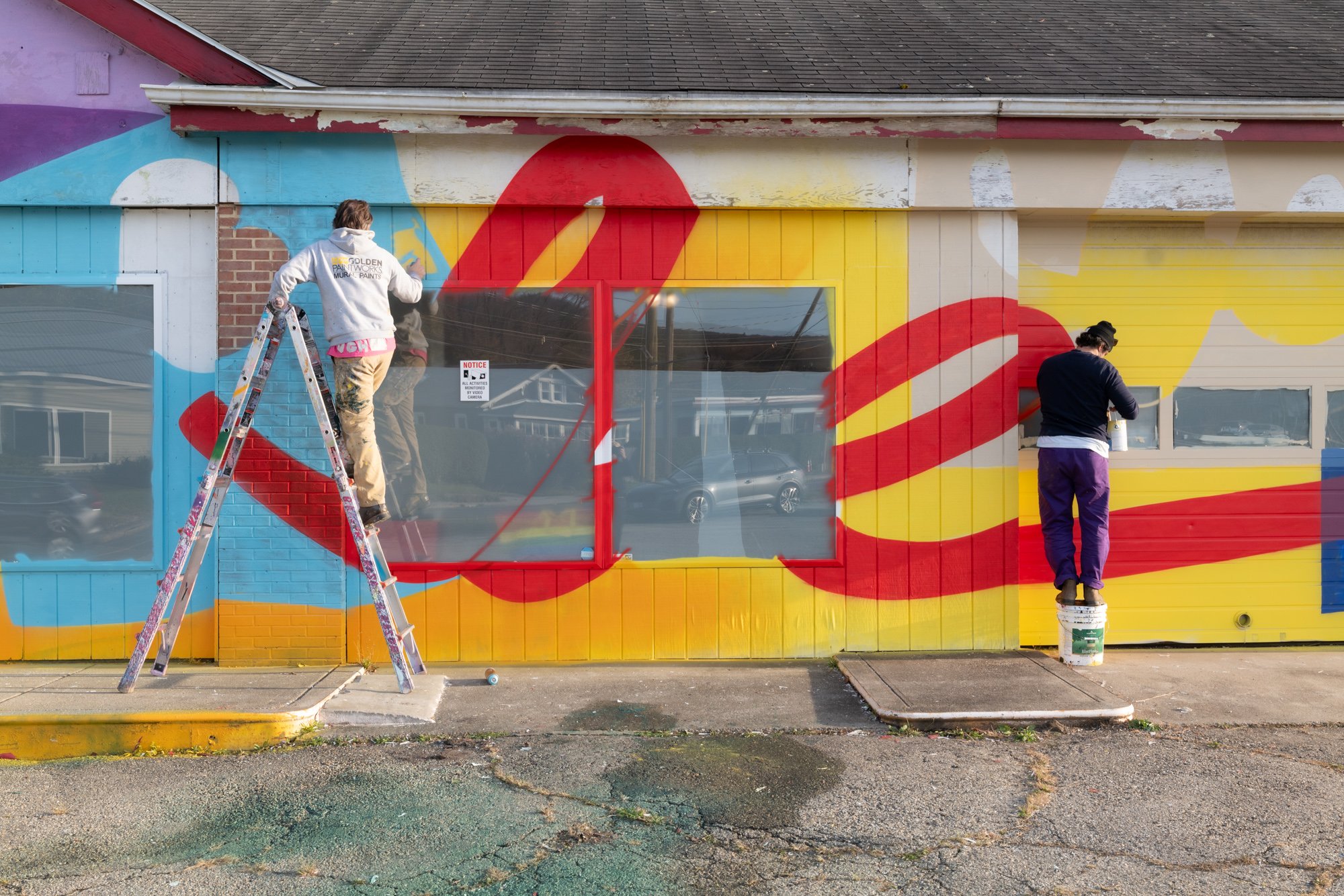 Aaron Oster and Brian Kaspr paint a mural for Berkshire Cider in North Adams, MA