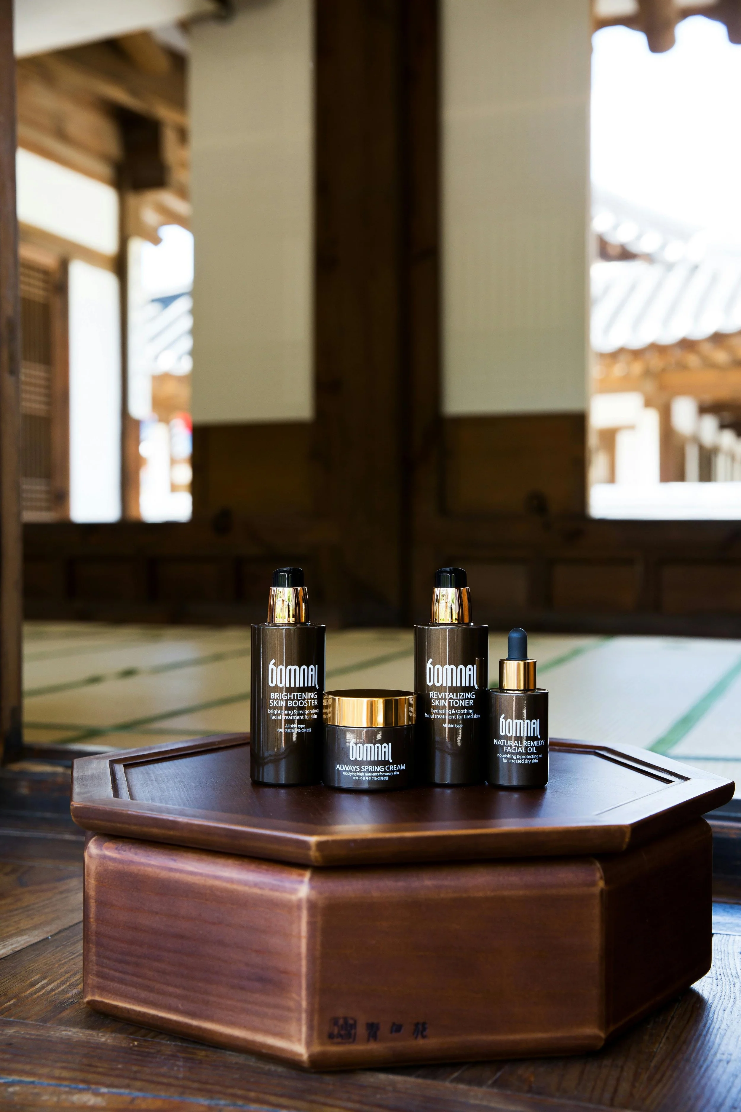 Skincare products on a wooden tray inside a traditional Japanese-style room with wooden flooring and sliding doors.