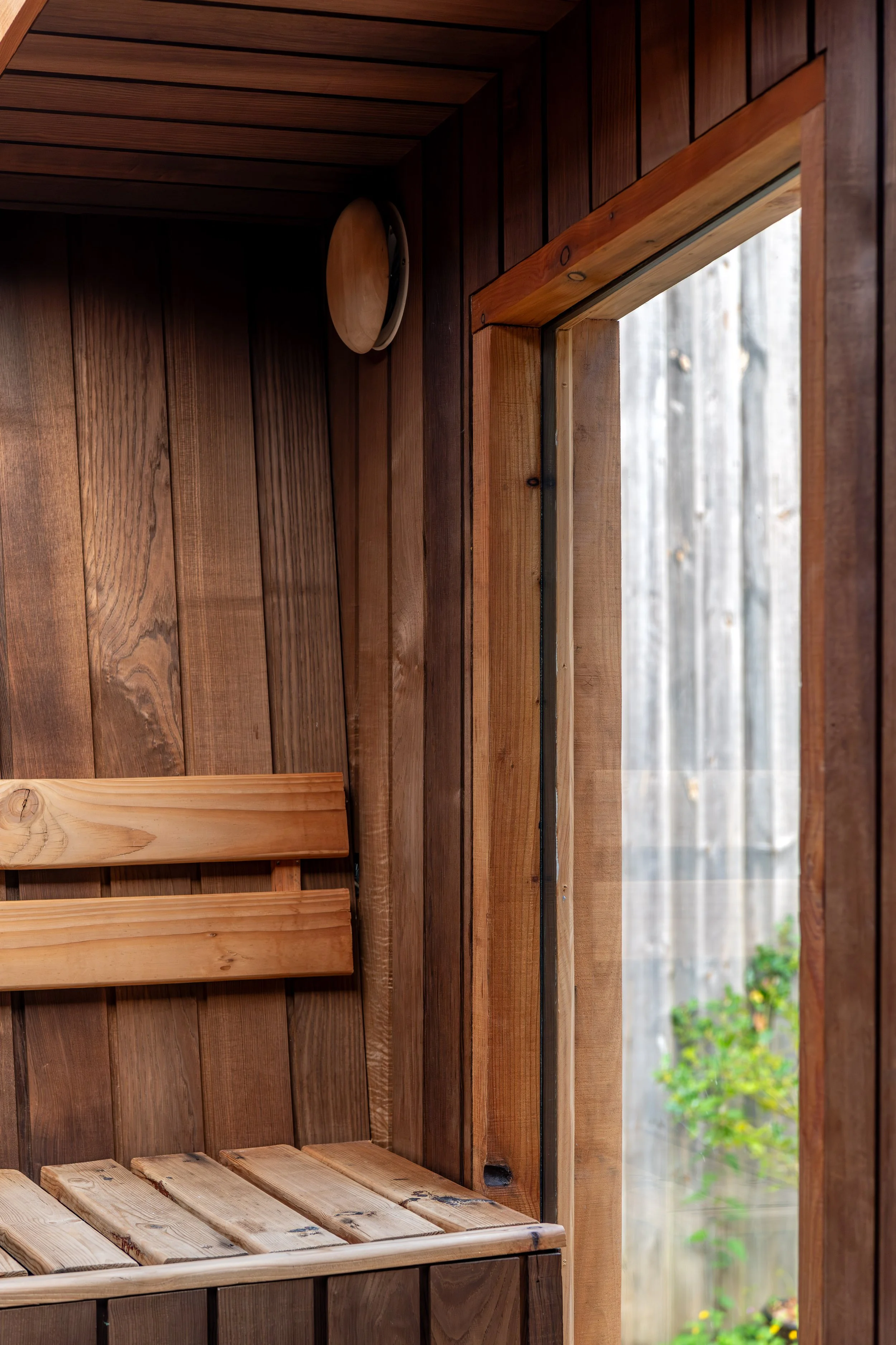 Wooden seats and insulated window inside custom sauna