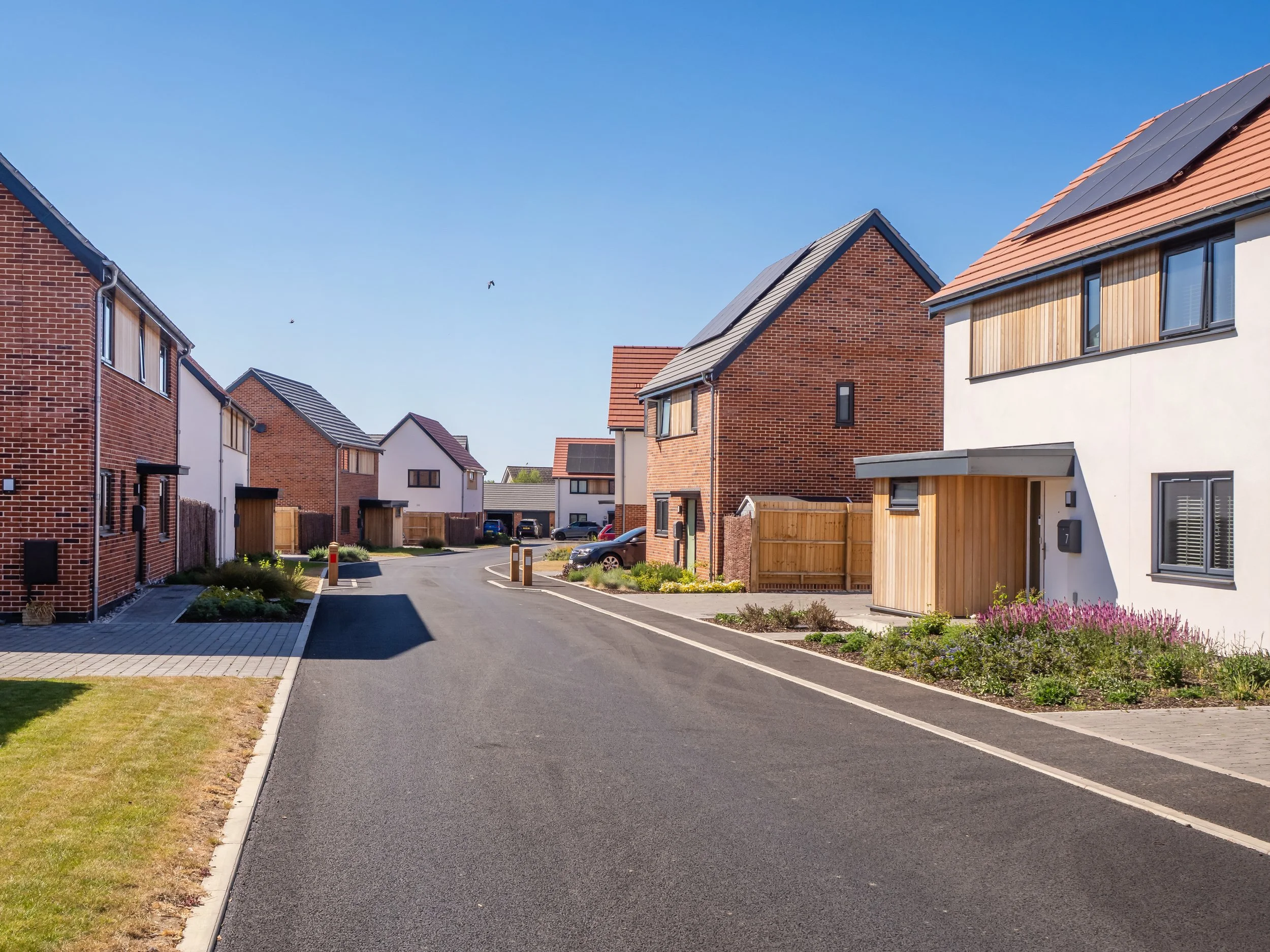 A street view of the "Three Squirrels" development, showing solar panels on the houses.