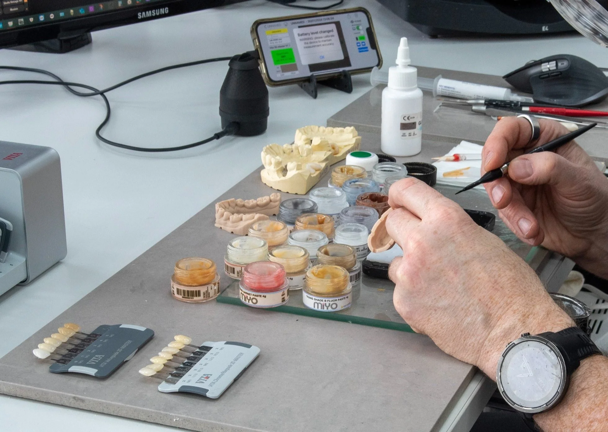 Dental technician at M POP Laboratory Solihull finishing a custom aesthetic restoration using digital shade protocols